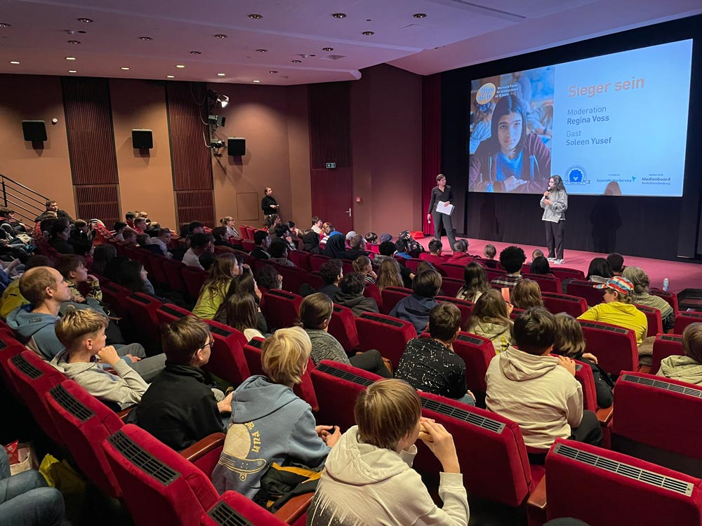 Zuschauer im Kino mit Regisseurin als Gast im Gespräch