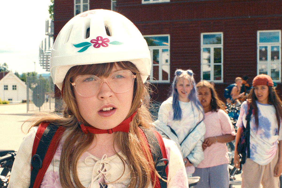 Mina mit Fahrradhelm und Brille, im Hintergrund ihre Mitschülerinnen