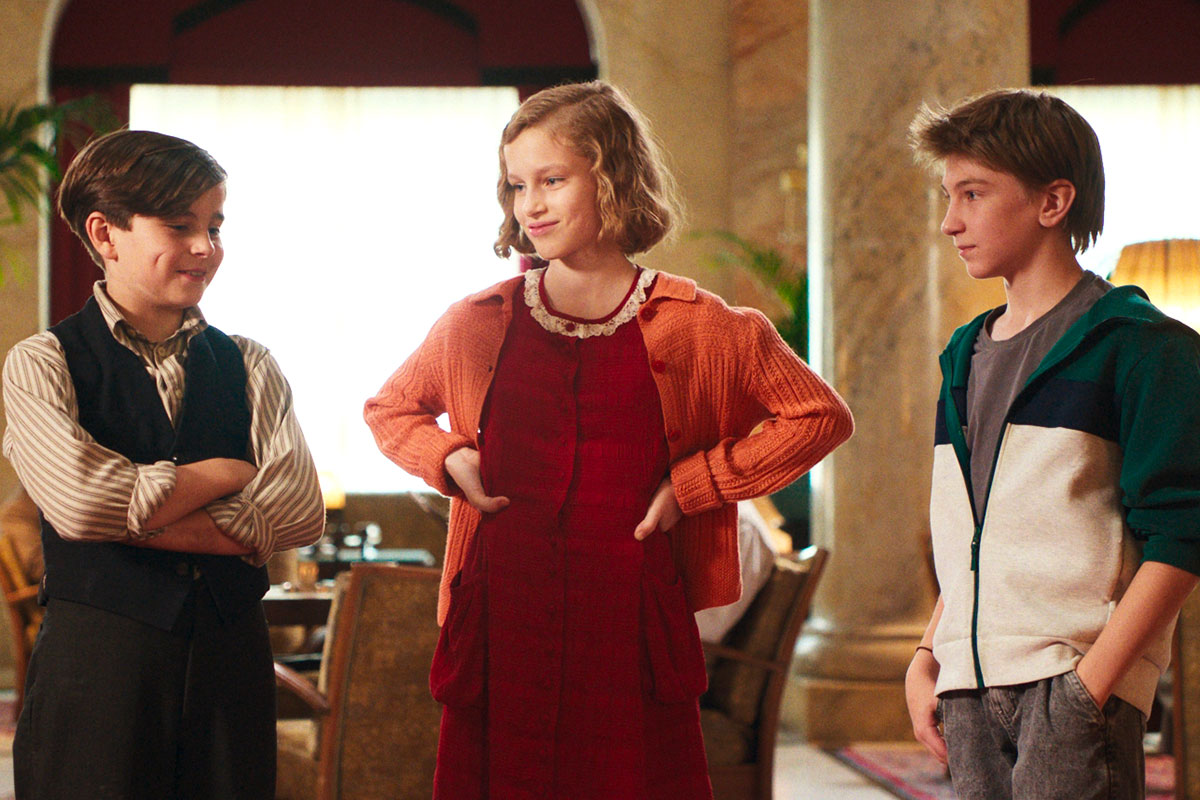 Georg, Hannah und Karli stehen im Hotel und reden miteinander