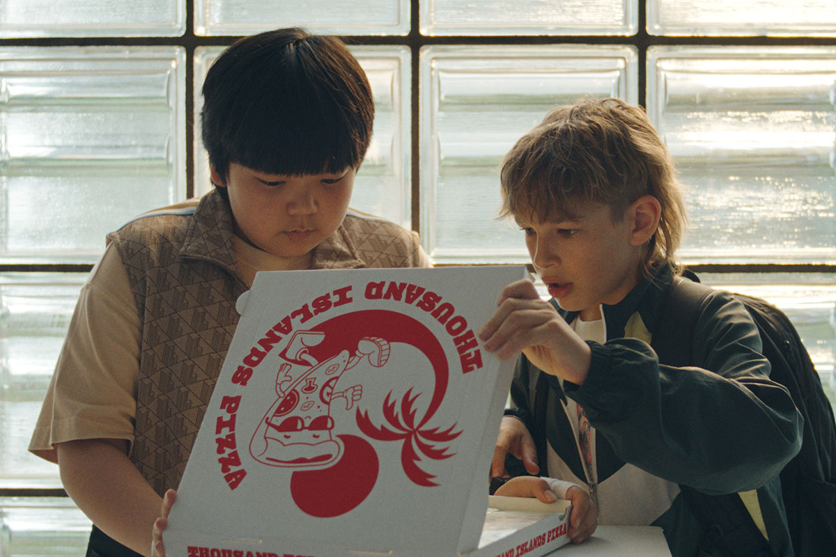 Lucas und Xi Zhōu öffnen einen Pizzakarton und staunen