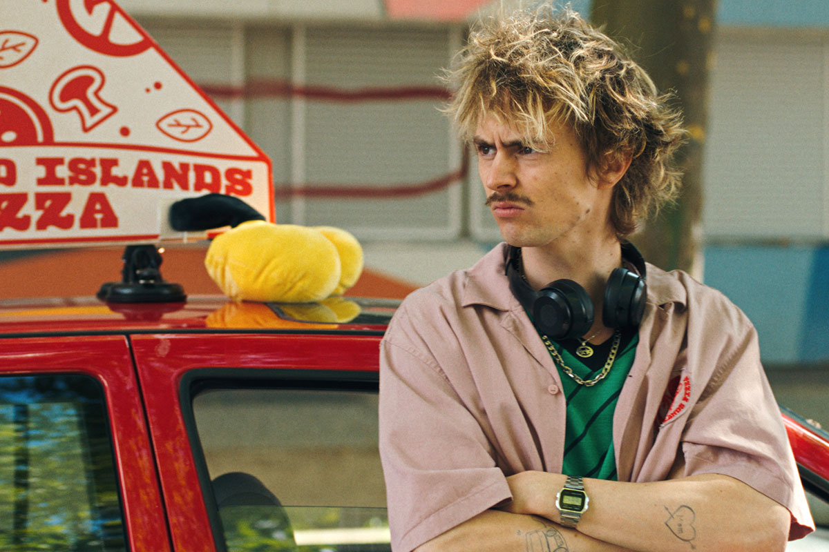 Schaaf steht genervt an sein rotes Pizza-Auto gelehnt und wartet