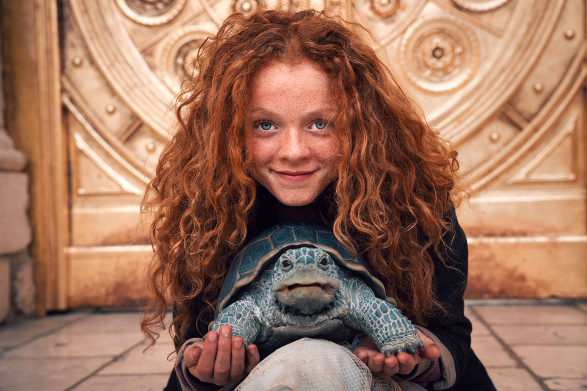 Momo mit der Schildkröte vor einer goldenen Tür